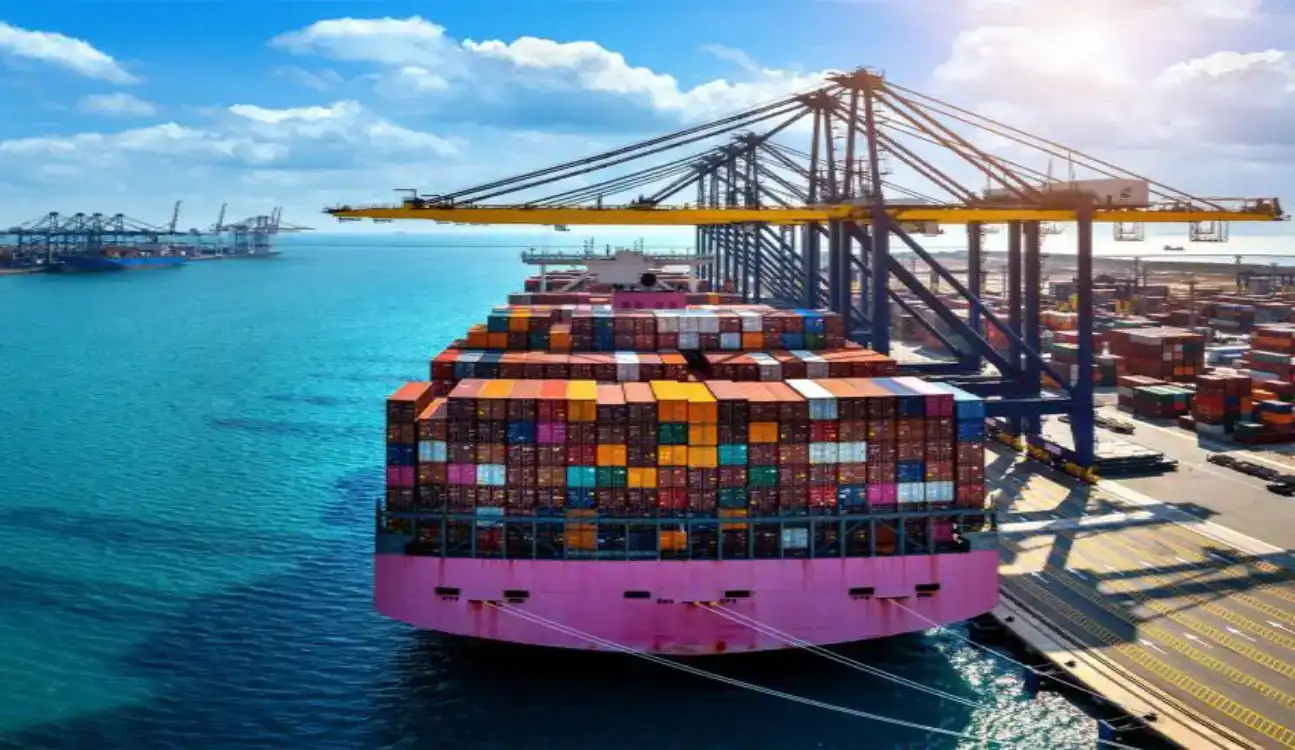 Container ship docked at busy port with yellow gantry cranes unloading containers